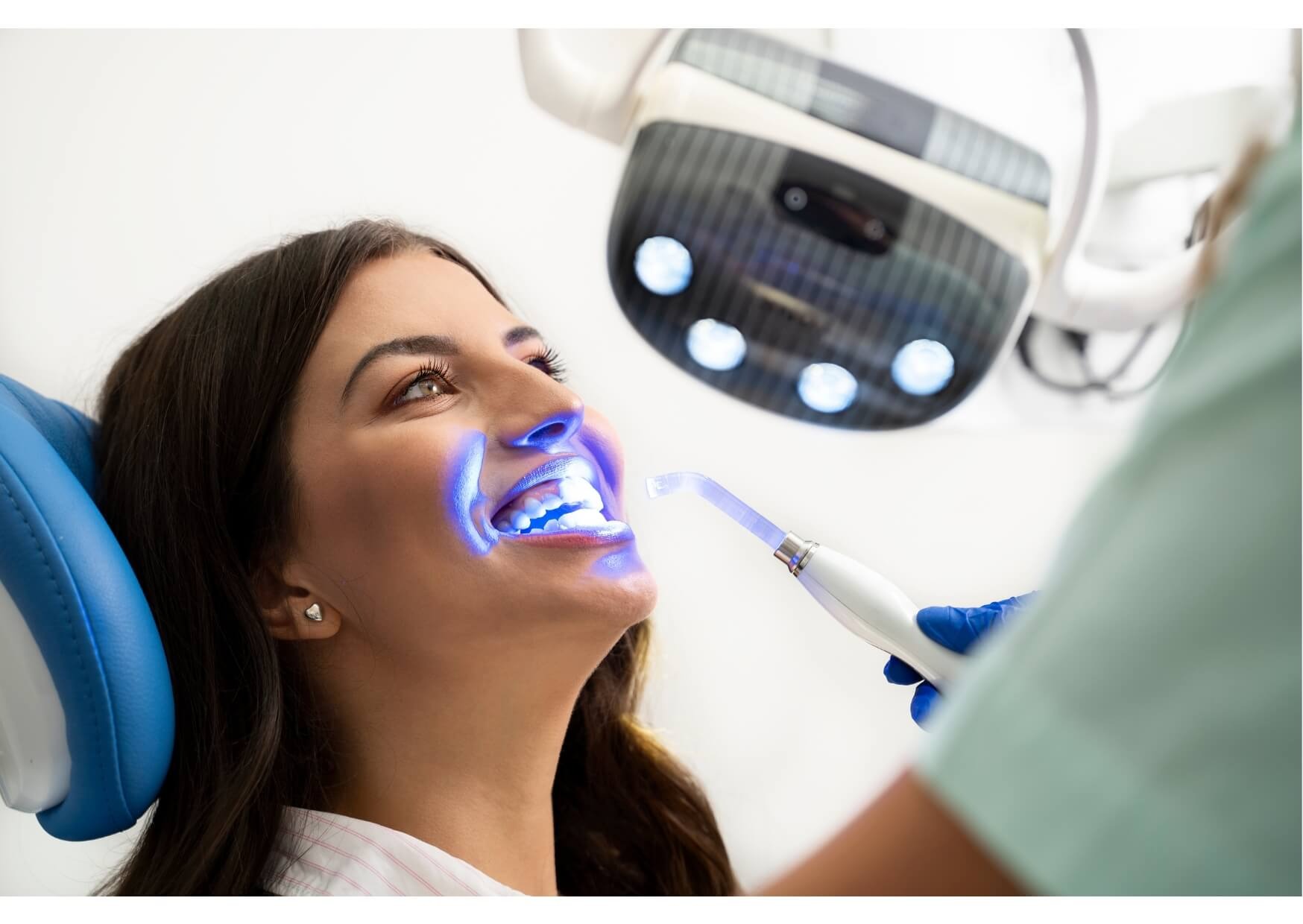 Patient undergoing professional teeth whitening treatment with LED whitening light at a dental office