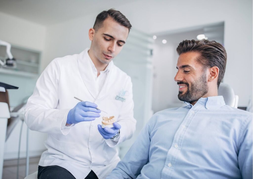 Dentist discussing treatment options with a patient, including evaluation and planning for dental implant removal or replacement.