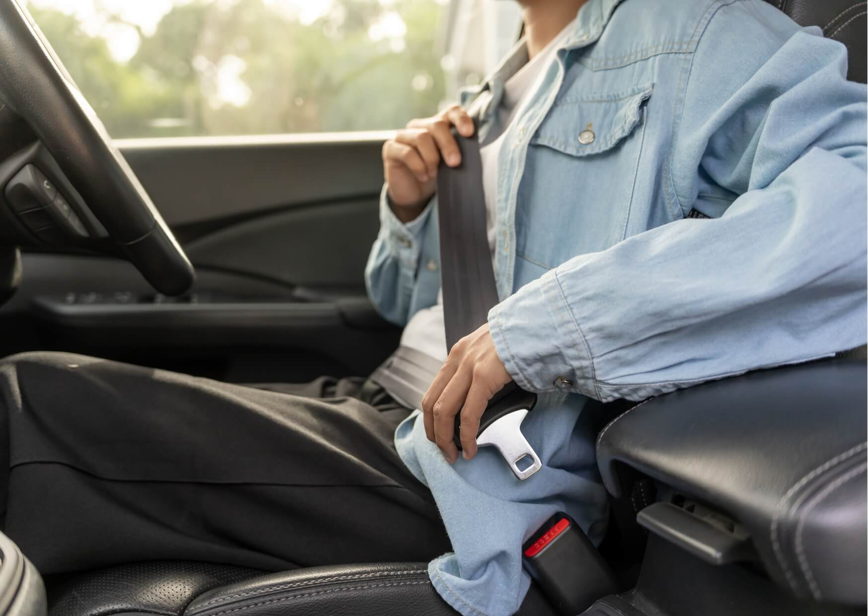 Person fastening a seat belt before driving, representing safety considerations and readiness to drive after a root canal appointment.