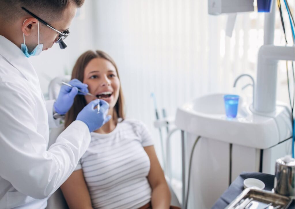Dentist examining a patient’s teeth during a consultation about tooth loss and whether a permanent tooth can grow back after extraction.