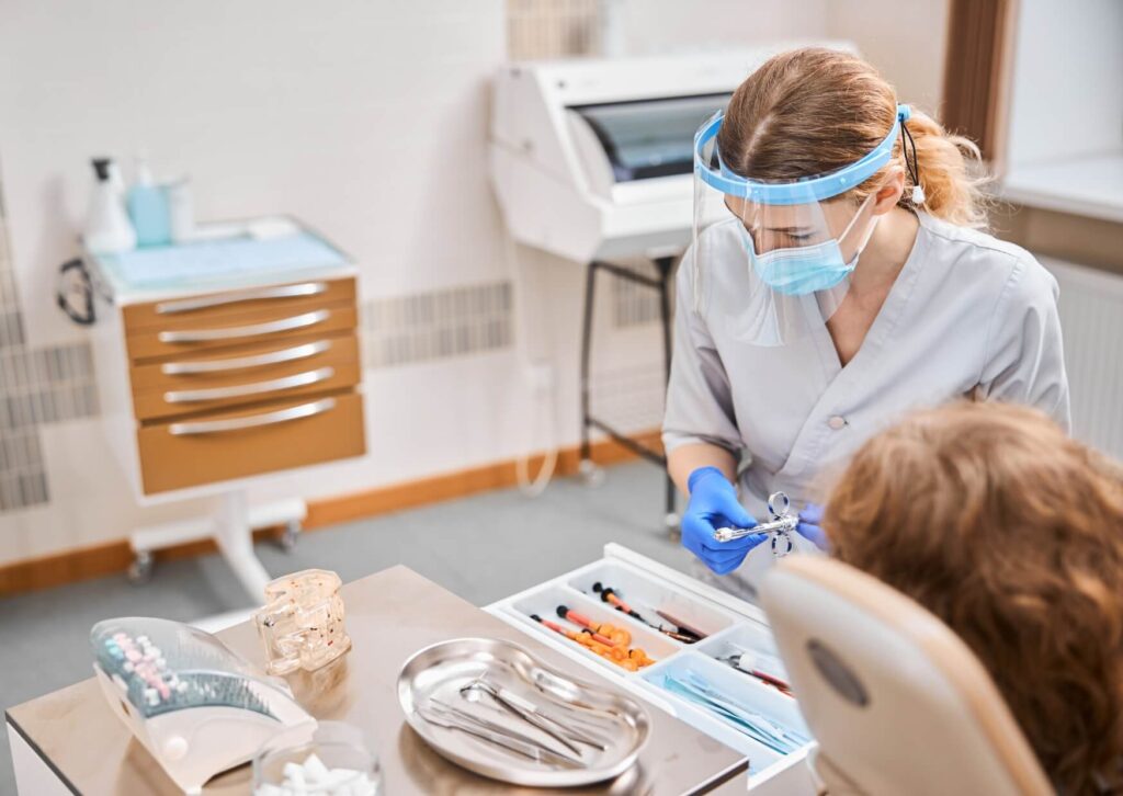 Dentist discussing wisdom tooth development with a patient during an exam to assess whether a wisdom tooth is coming in normally.
