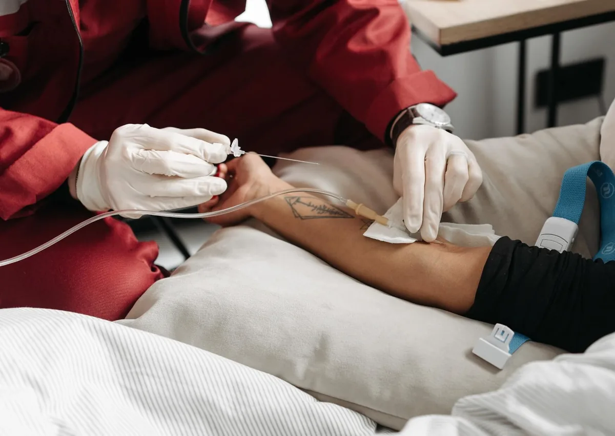 Healthcare professional administering an IV line used to provide dental sedation during a procedure.