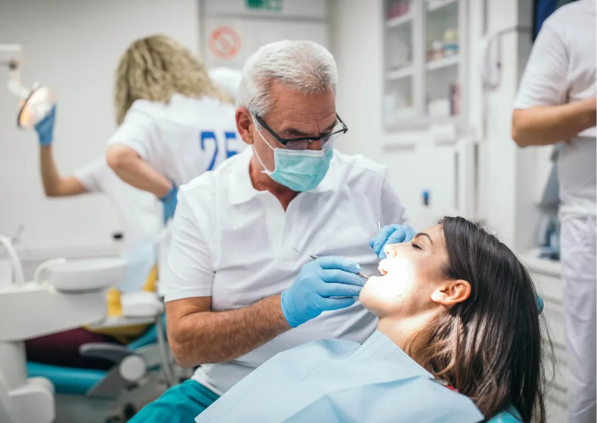 Dentist examining a patient’s teeth during a consultation for tooth contouring and cosmetic reshaping.