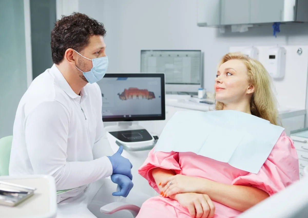 Dentist discussing human tooth count and dental development with a patient during a consultation.