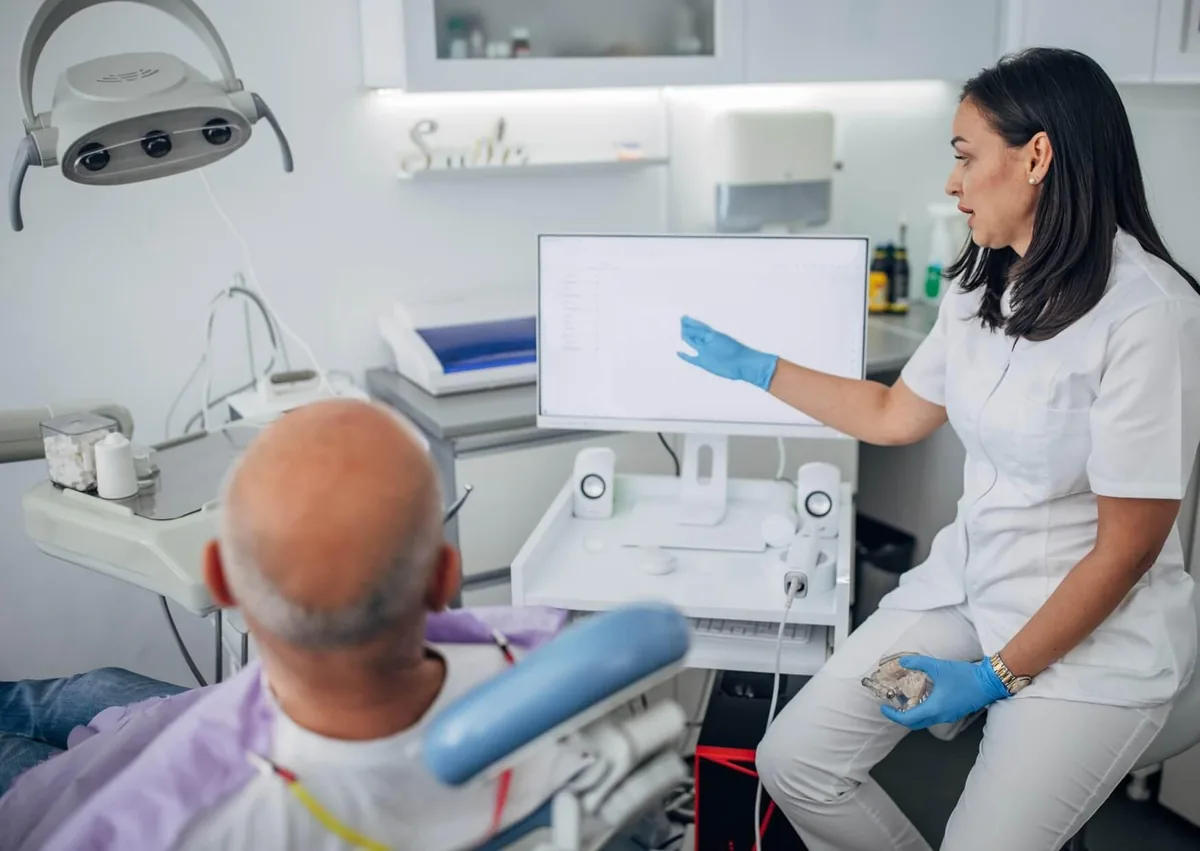 Dentist discussing sedation options with a patient before dental implant treatment.